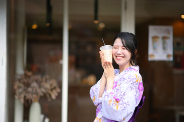 Japanese woman smile with yukata dress and milk tea in hand
