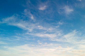 Obraz premium A beautiful blue sky with wispy clouds, perfect for creating a sense of calm and serenity. Ideal for backgrounds, nature themes, or uplifting designs.