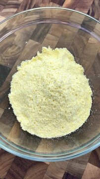 pouring salt over corn flour to season it and salt it.