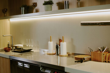 Wooden kitchen counter with kitchenware and dishes on white granite top