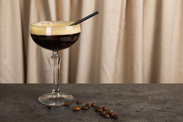 Fresh coffee cocktail in glass and beans on grey table, space for text
