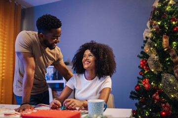 Joyful african american couple bonding while preparing holiday decorations
