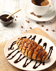 Croissant and coffee, coffee and croissant in a cup on the table