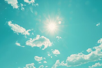 A sunny day with bright light shining through white clouds in a clear blue sky
