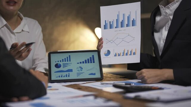Business professionals engaging in a meeting, discussing financial charts and graphs for strategic analysis and planning