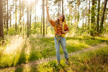 Young woman went on a hike in the forest feeling free and full of energy. Autumn landscape.