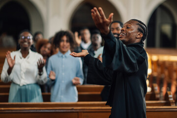 Preacher delivering passionate sermon to diverse congregation in church