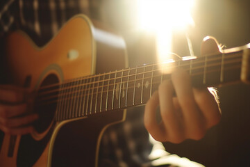 Acoustic guitar being played in warm golden light for music, live performance, or artistic concepts focusing on the beauty of sound and instruments