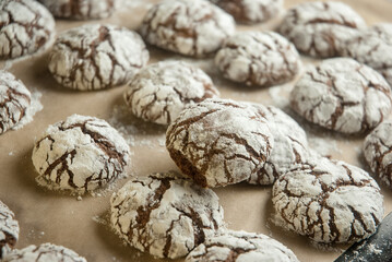 Chocolate cookies with white powder on baking sheet, sweet dessert.