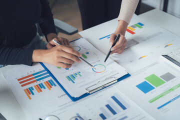 Business Analysis: Close-up of two hands pointing at financial data on a clipboard, showcasing the...