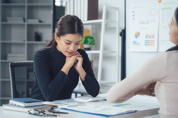 Focused Businesswoman in Meeting: A serious and attentive young businesswoman sits at her desk,...
