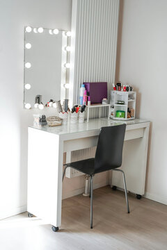 coiffeuse avec une chaise et un miroir, pour se maquiller, se pr&eacute;parer, se faire belle avec tout le maquillage et produits de beaut&eacute;