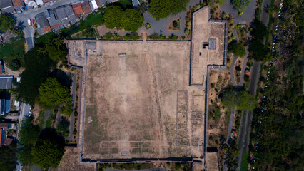 Aerial view of a large fortress surrounded by trees and urban environment, showcasing potential for development and space utilization