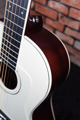 Obraz premium Violão com tampo branco em fundo de tijolo à vista
