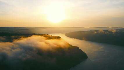 Aerial view of sunrise over misty river valley. A breathtaking aerial view of the sunrise illuminating a misty river valley.