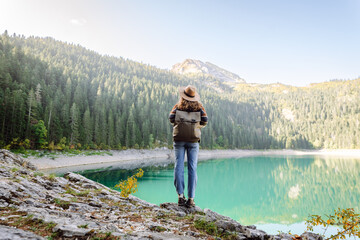 A Moment of еranquility by the Lake. Back view of female tourist enjoying nature. Active lifestyle.