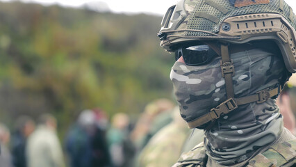 Military personnel in camouflage gear with tactical helmet. Close-up of a military personnel...