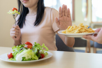 Beauty slim female body confuse French fries. Woman in restaurant achieves weight loss goal for healthy life, crazy about thinness, thin waist, nutritionist. Diet, body shape.
