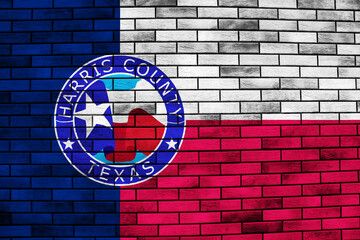 Obraz premium Flag of the city of Harris County, Texas, USA, on a background of a brick wall. Conceptual collage