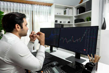 Smart trader businessman analyzing in two dynamic stock exchange investment screen on pc with investing highest profitable financial technology in searching market at modern home office. Surmise.