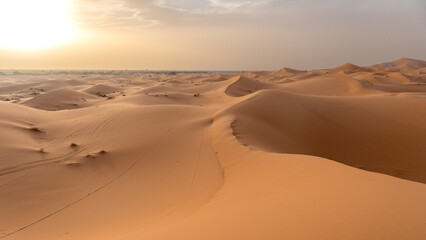 Dunes of Erg Chebbi at sunset with yellow sky from dust haze
