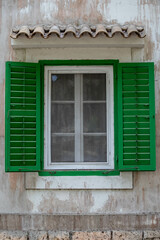 an old window with green shades and a green frame