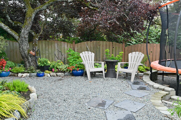 Obraz premium Backyard patio and garden space designed to share space for kids play area and trampoline. Multi use spaces in home landscaped outdoor spaces