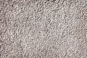 Rough textured wall surface with detailed grain. A close-up view of a rough, grainy textured wall, displaying its rugged surface with intricate details.