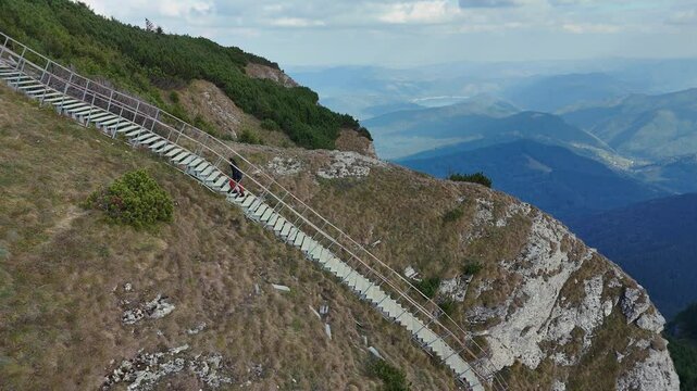 Drone captures male climber ascending ladder on Toaca Peak, Ceahlau, Romania