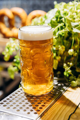 Cold beer with frothy head served in traditional beer glass, perfect for bar, pub