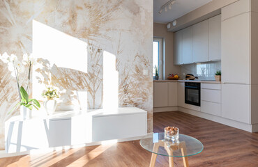Modern living room interior with kitchen and wallpaper on the wall with light. Real estate with luxurious design and wooden floor. Bright apartment in hotel.