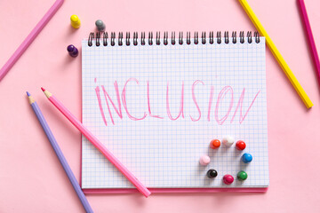 Notebook with word INCLUSION, pencils and pawns on pink background