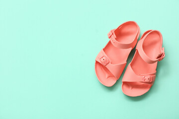 Pair of stylish child's sandals on color background