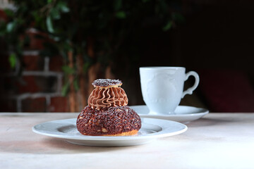 French custard cake on a white plate. There is a cup of coffee on the table. A modern dessert. A confectionery product.