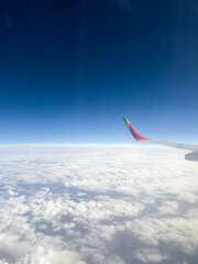 airplane wing over white clouds