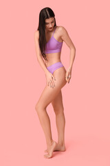 Fototapeta premium Beautiful young woman with massage brush on pink background
