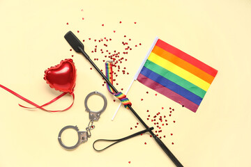 Sex toys with heart shaped decor and rainbow LGBT flag on yellow background. Valentine's Day...