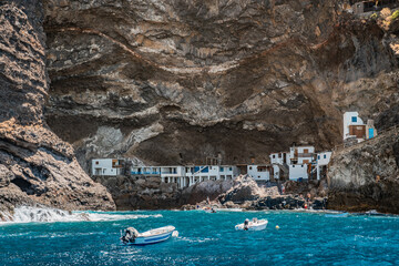 Coastal village next to cliffs with boats in turquoise waters. Porís de Candelaria on the island...