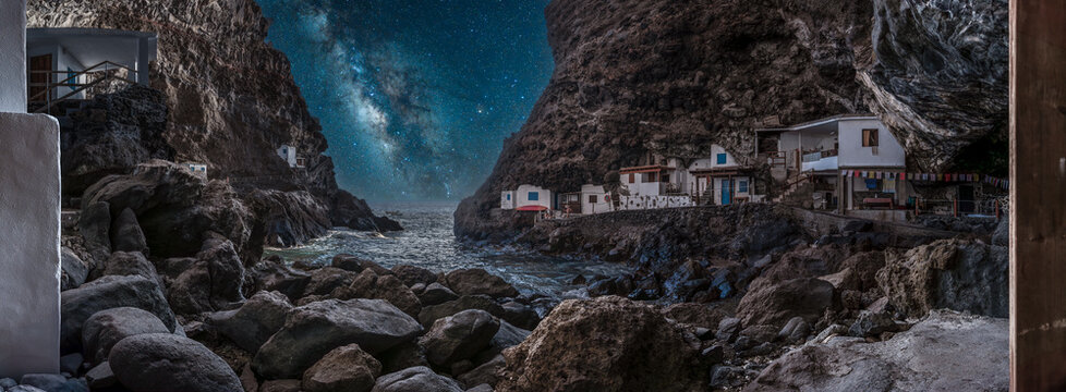 Porís de Candelaria on the island of La Palma. Starry sky over cliffside village by the sea - Powered by Adobe