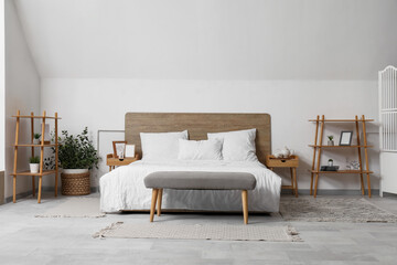 Interior of stylish bedroom with big bed and shelving unit