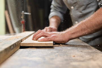 A carpenter mills an oak part with a milling cutter