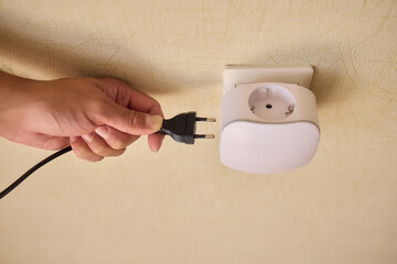 Hand Plugging in an Electrical Device for Essential Power Supply and Utility Connection