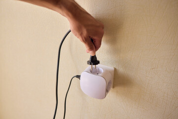 Hand Plugging in an Electrical Device for Essential Power Supply and Utility Connection