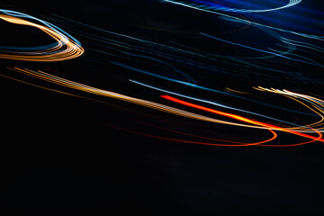 A black background with orange and blue streaks. The streaks are moving and appear to be in motion