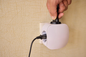 Hand Plugging in an Electrical Device for Essential Power Supply and Utility Connection