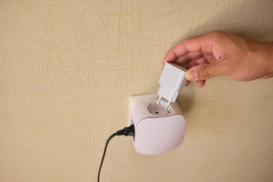 Hand Plugging in an Electrical Device for Essential Power Supply and Utility Connection