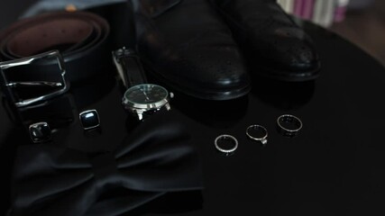black men's shoes and a watch on the table in the room men's accessories