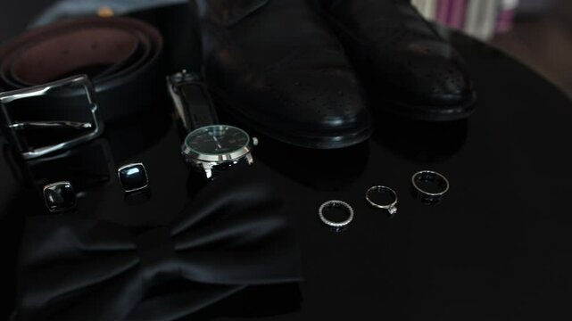 black men's shoes and a watch on the table in the room men's accessories