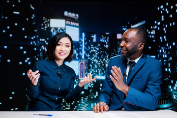 Journalists team on late night show discussing about latest information from media newspapers, global communications. Diverse presenters working on television content, broadcasting live.
