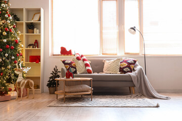 Obraz premium Sofa and beautiful decorated Christmas tree in interior of light living room
